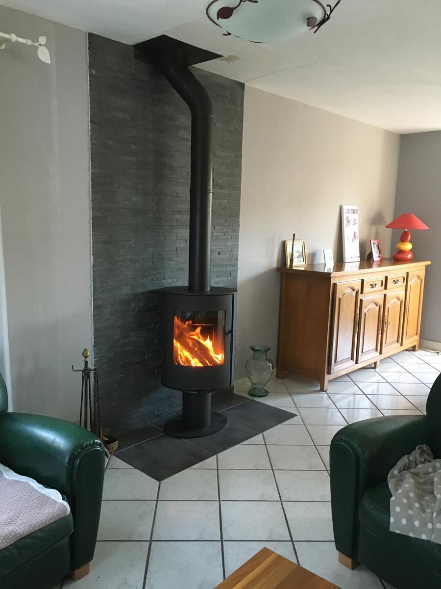 Installation d'un poêle à bois ROMOTOP Evora T, finition acier, appareil rotatif à 360°.